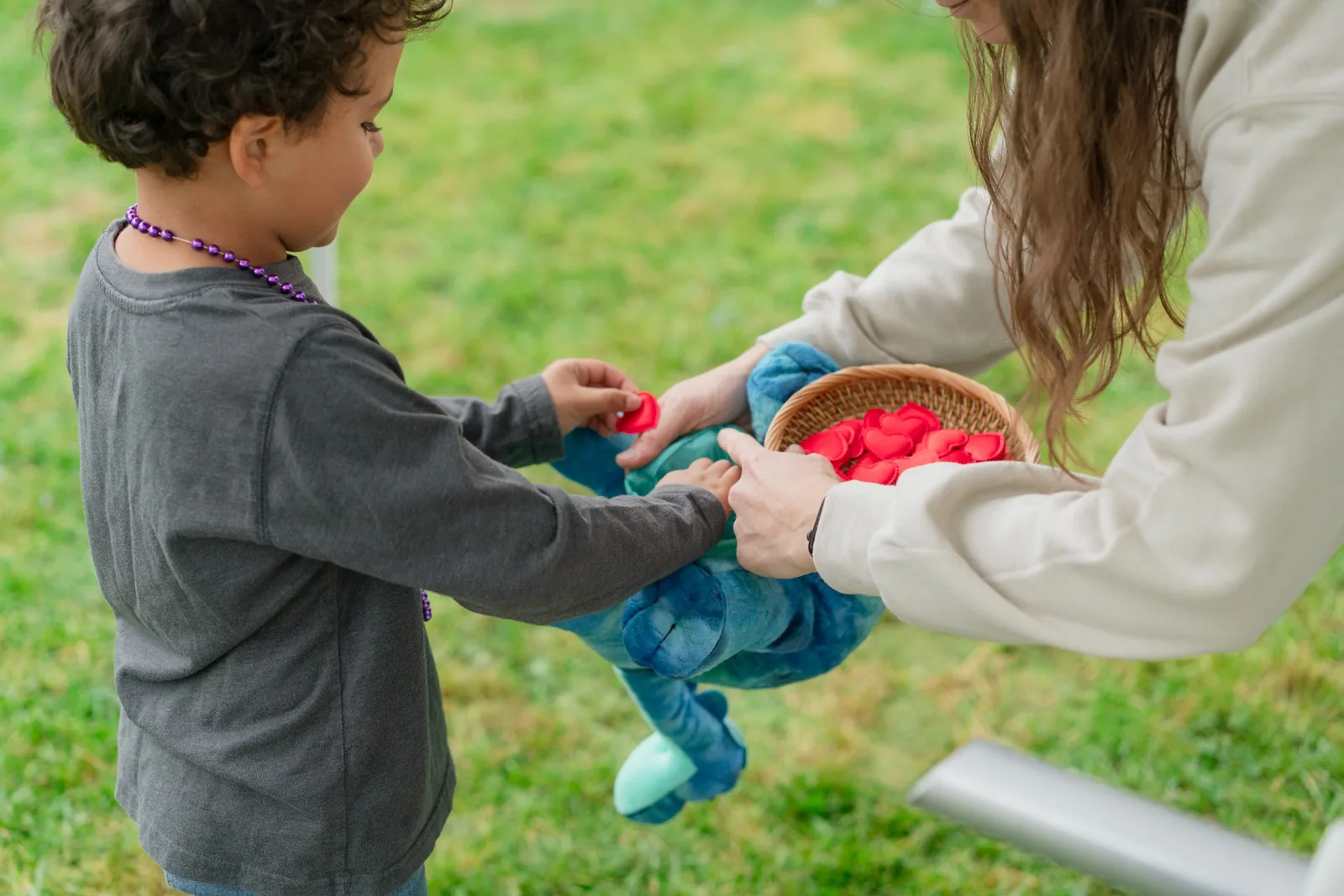Child placing a wishing heart inside a Stuffed With Love plush