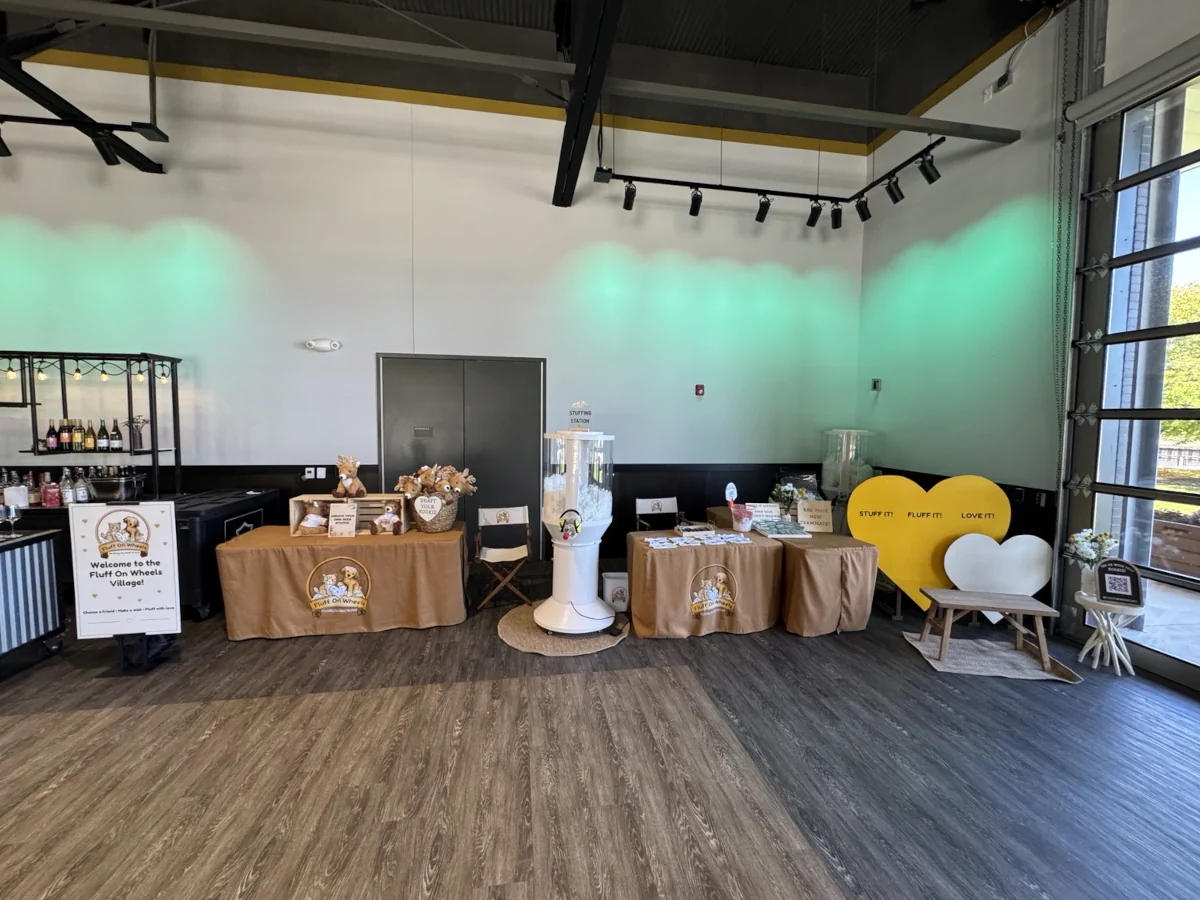 Fluff On Wheels event setup with live stuffing station, plush display, and photo area